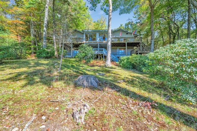 rear view of property featuring a yard and a deck