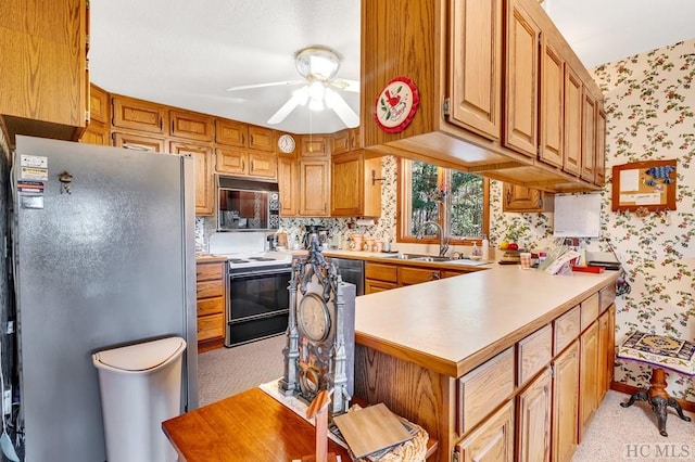 kitchen with sink, electric range, stainless steel refrigerator, kitchen peninsula, and ceiling fan