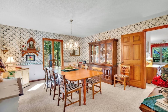 carpeted dining area with an inviting chandelier and a textured ceiling