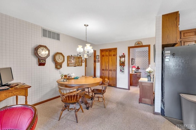 carpeted dining space with an inviting chandelier