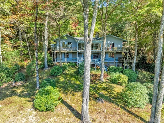 view of front of property with a deck and a front lawn