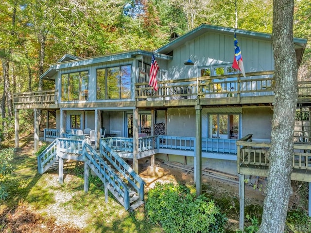 back of house featuring a wooden deck and a sunroom