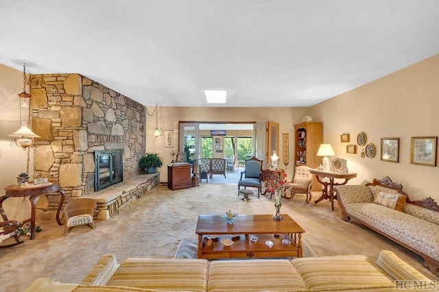 carpeted living room featuring a stone fireplace