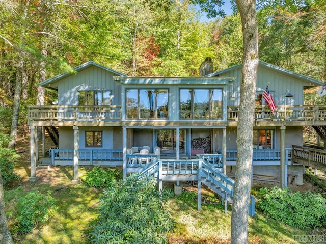 back of property featuring a sunroom and a deck