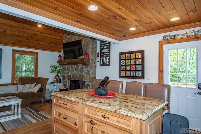 kitchen featuring a center island, light stone countertops, wooden ceiling, and light brown cabinetry