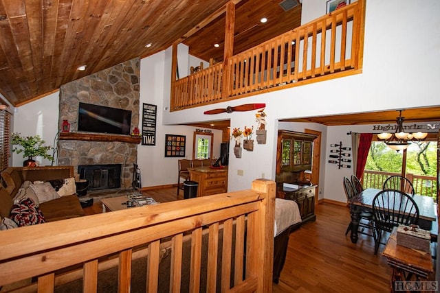 living room with wood ceiling, a stone fireplace, wood-type flooring, high vaulted ceiling, and a chandelier