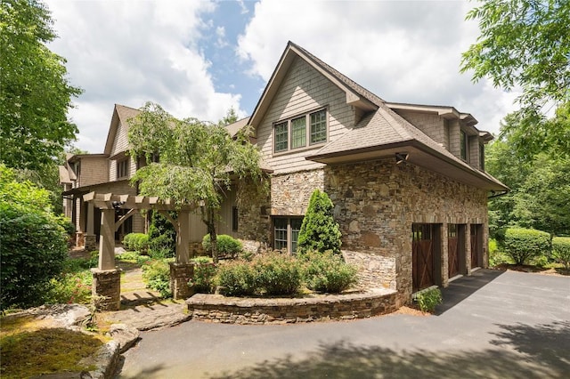 115 Falls Ct W, Highlands, NC 28741 - view of side of home featuring stone siding, asphalt driveway, an attached garage, and a pergola