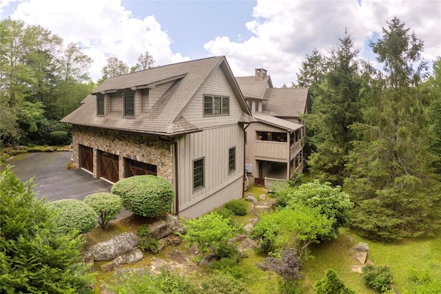 115 Falls Ct W, Highlands, NC 28741 - view of side of home featuring a chimney, an attached garage, and stone siding