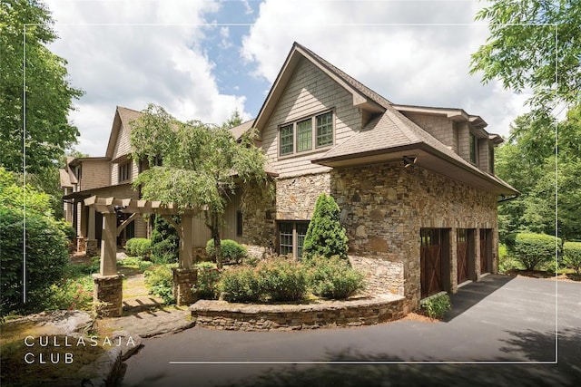 115 Falls Ct W, Highlands, NC 28741 - view of side of home featuring stone siding, asphalt driveway, and an attached garage