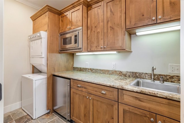 115 Falls Ct W, Highlands, NC 28741 - kitchen featuring stainless steel microwave, stacked washer / dryer, fridge, brown cabinetry, and ornamental molding