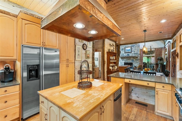 kitchen featuring wooden counters, a center island, hanging light fixtures, wooden ceiling, and stainless steel appliances