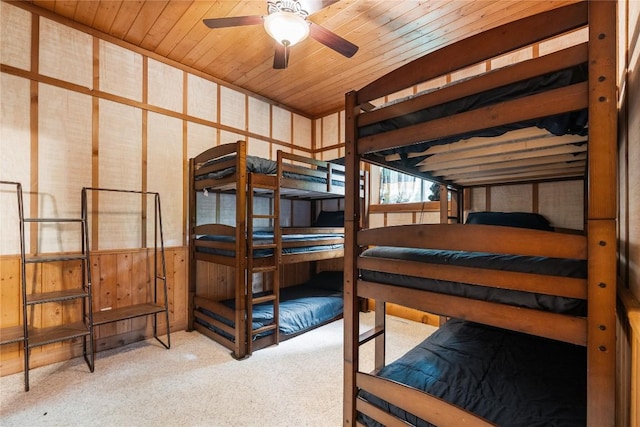 bedroom featuring wood ceiling, light colored carpet, and wooden walls