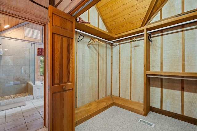 spacious closet featuring vaulted ceiling and light tile patterned floors