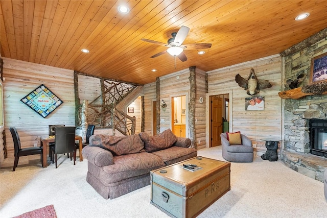 carpeted living room featuring wood ceiling, ceiling fan, a fireplace, and rustic walls