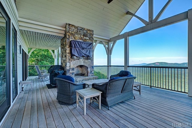 wooden terrace featuring ceiling fan, a water and mountain view, and an outdoor living space with a fireplace