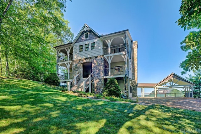 view of front of house featuring a balcony and a front yard