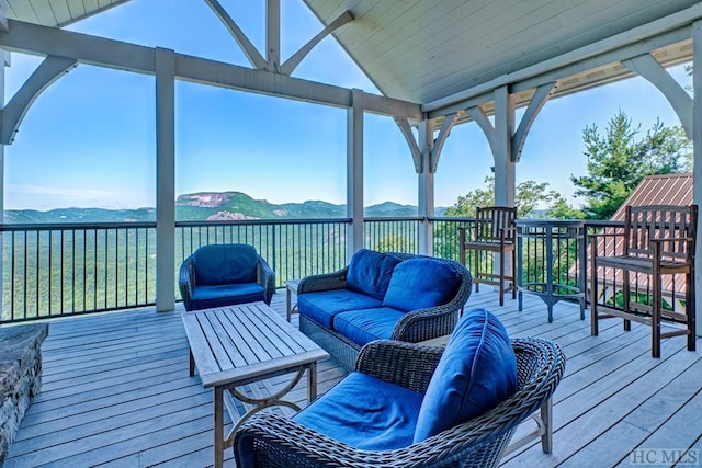 wooden deck featuring a mountain view and an outdoor hangout area