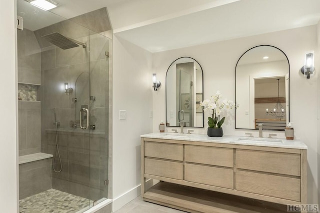 bathroom with vanity, tile patterned flooring, a shower with door, and an inviting chandelier