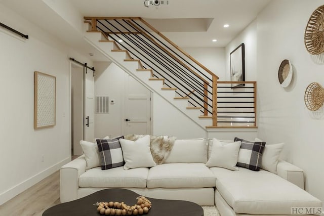 living room featuring a barn door and light wood-type flooring