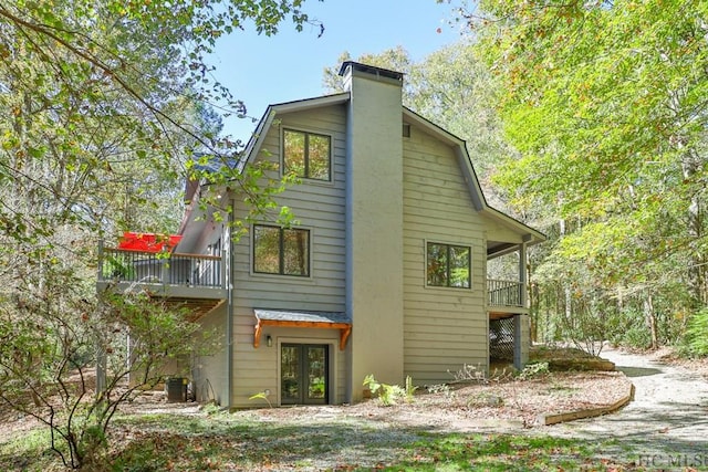 view of side of home with french doors and central AC