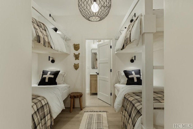 bedroom with ensuite bathroom and light wood-type flooring