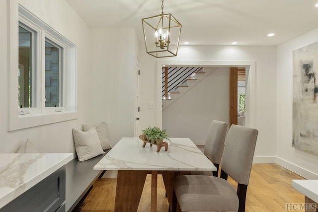 dining area with a notable chandelier and light hardwood / wood-style floors