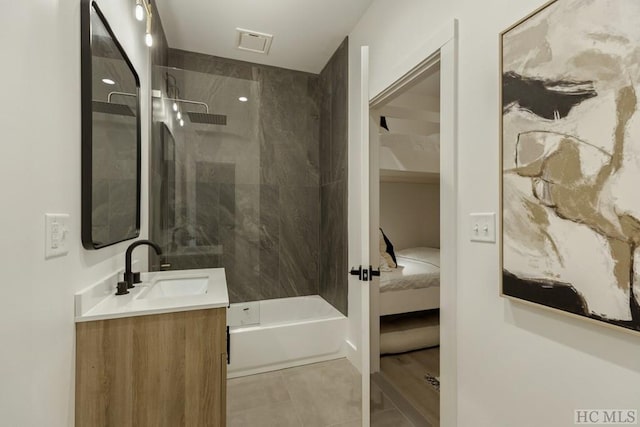 bathroom featuring vanity and tiled shower / bath