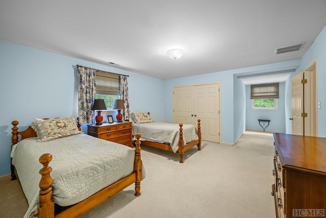 bedroom featuring light carpet and a closet