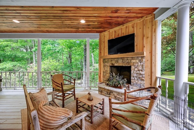 wooden deck featuring an outdoor stone fireplace