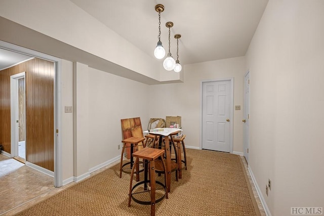 carpeted dining room with wood walls