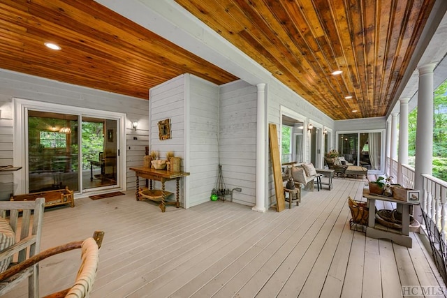 sunroom with wood ceiling, plenty of natural light, and decorative columns