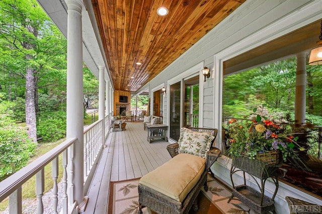 wooden deck with an outdoor stone fireplace