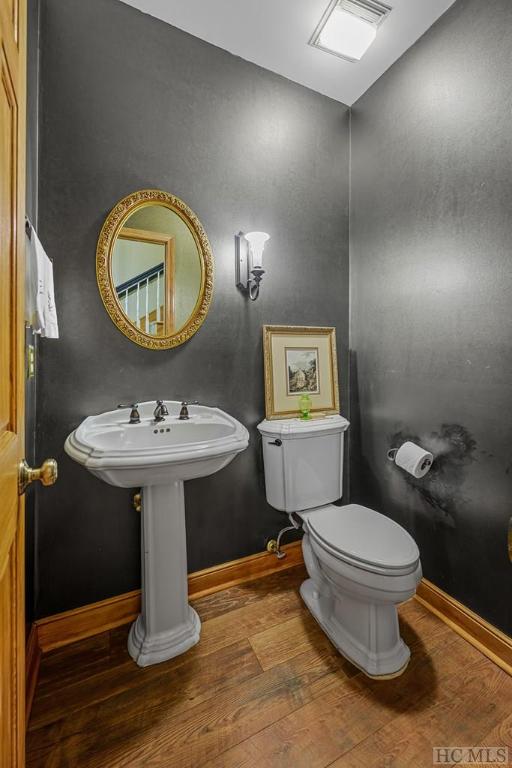 bathroom featuring hardwood / wood-style flooring and toilet