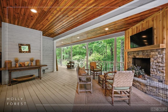 interior space featuring a stone fireplace and wooden ceiling