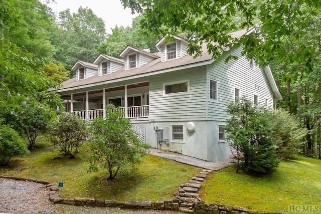 exterior space featuring covered porch and a front lawn