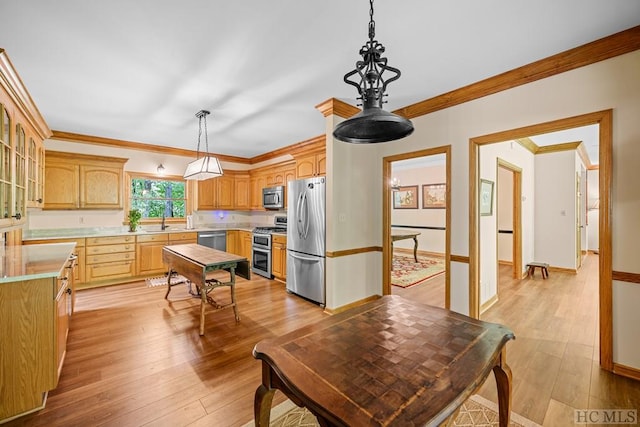 kitchen featuring crown molding, stainless steel appliances, light hardwood / wood-style floors, and hanging light fixtures