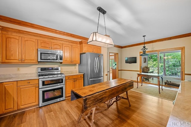 kitchen featuring stainless steel appliances, ornamental molding, pendant lighting, and light hardwood / wood-style floors