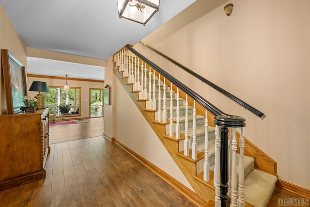 stairway featuring ornamental molding and hardwood / wood-style floors