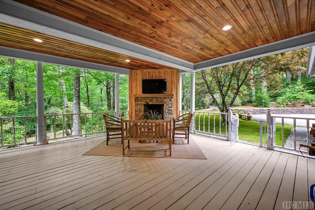 wooden terrace with an outdoor stone fireplace