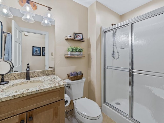 bathroom with a shower stall, toilet, and vanity