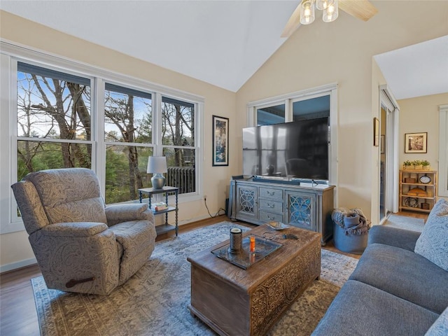 living area with ceiling fan, baseboards, lofted ceiling, and wood finished floors