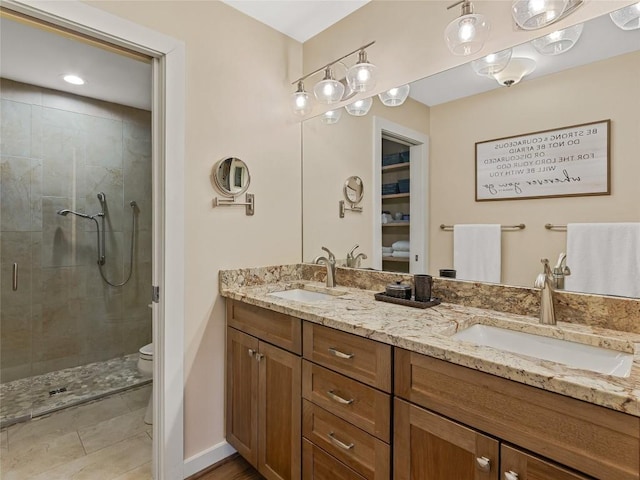 bathroom featuring a sink, toilet, a stall shower, and double vanity