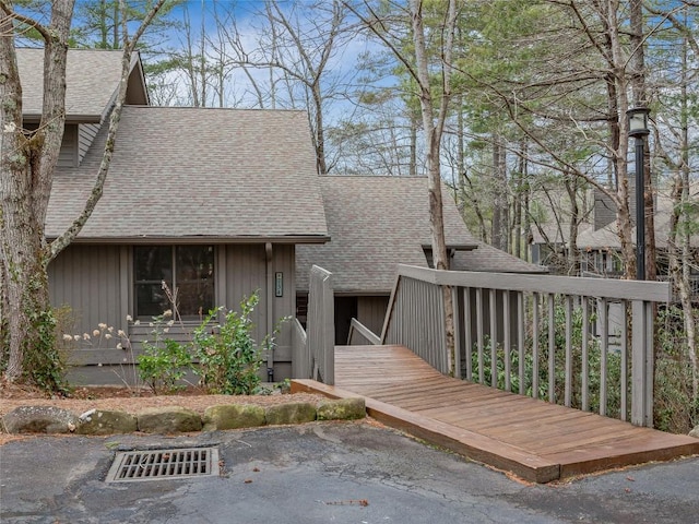 view of front of property with roof with shingles and a deck