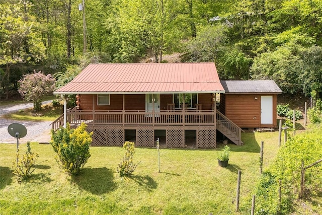 rear view of property featuring a porch, a lawn, and metal roof