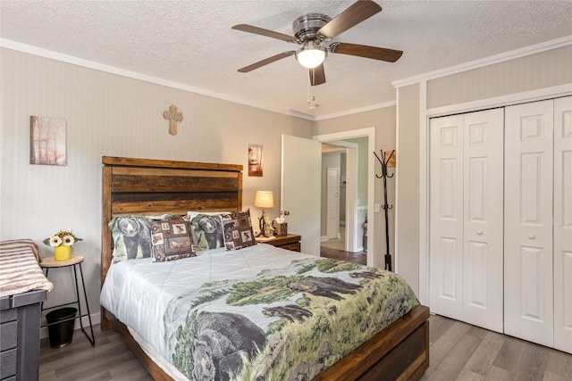 bedroom featuring wood finished floors, ornamental molding, a closet, a textured ceiling, and a ceiling fan