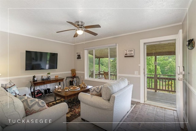 living room featuring ceiling fan, crown molding, and a textured ceiling