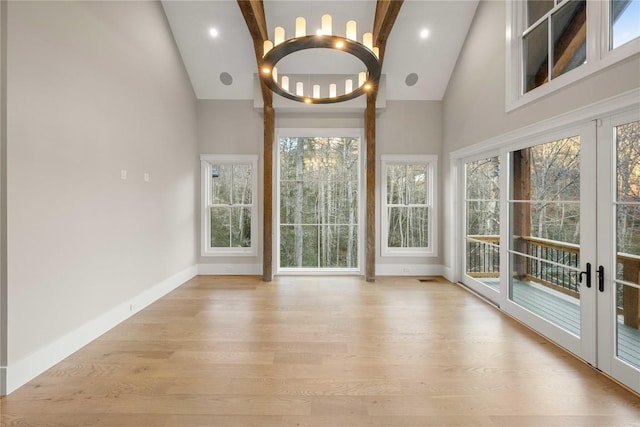 unfurnished sunroom featuring visible vents, vaulted ceiling, a notable chandelier, and french doors