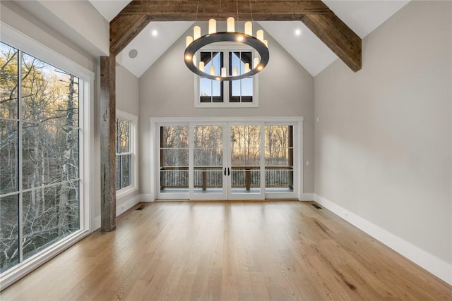 interior space featuring baseboards, wood finished floors, beamed ceiling, high vaulted ceiling, and a notable chandelier