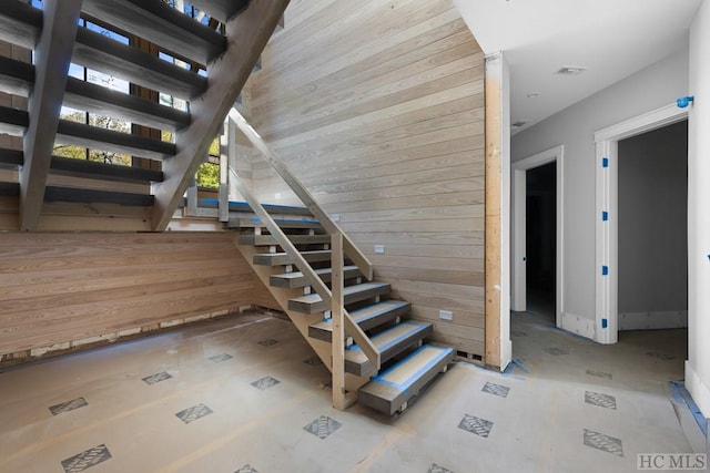 stairs featuring wood walls