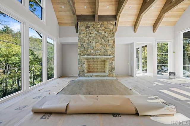 unfurnished living room with high vaulted ceiling, beamed ceiling, and wooden ceiling